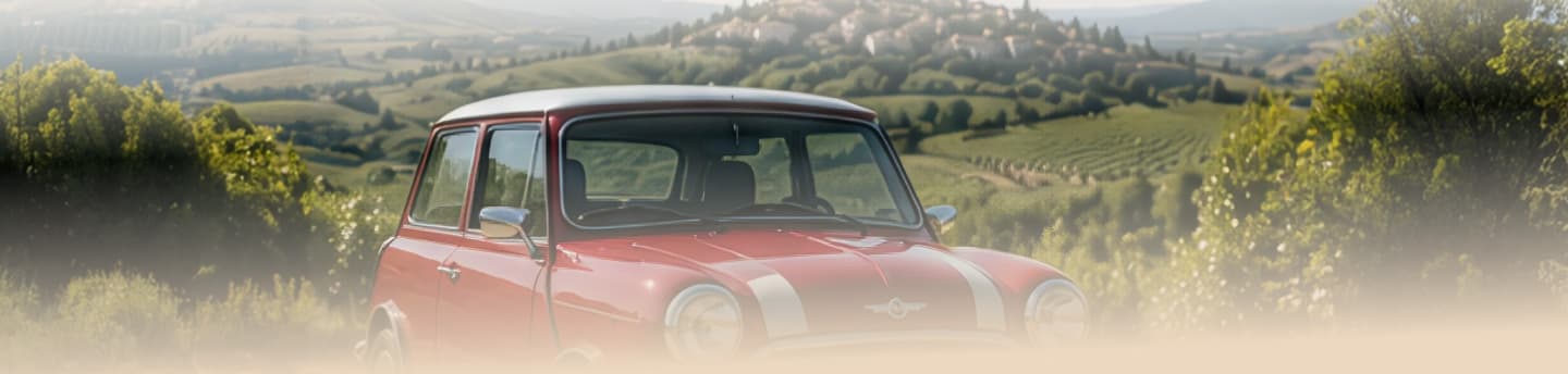 Une Austin Mini rouge à toit crème, à l’arrêt au sommet d’un coteau planté de vignes.